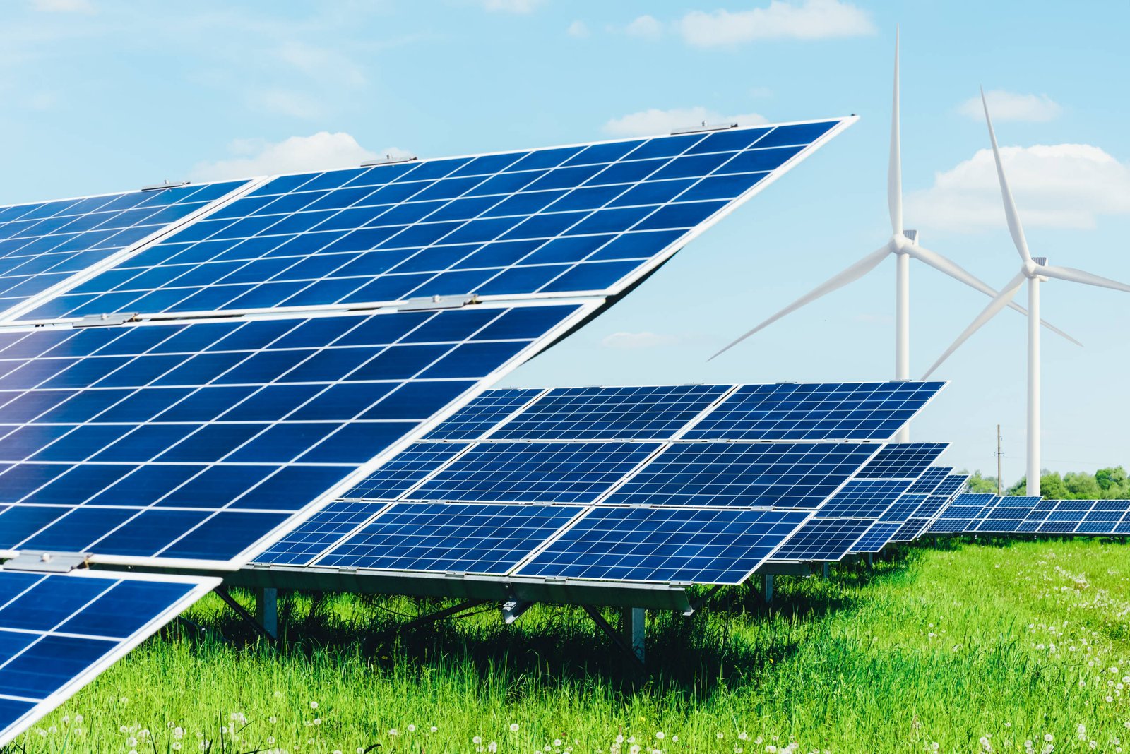 Solar panel on blue sky background. Green grass and cloudy sky. Alternative energy concept